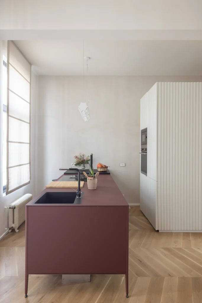 Rénovation d'un appartement dans le quartier européen de Bruxelles où les différents espaces et les différentes fonctions sont divisés par des volumes matériels et colorés.
Une armoire en fenix ​​rouge jaipur sépare la chambre du salon et souligne la hauteur de l'espace typique des maisons d'autrefois.